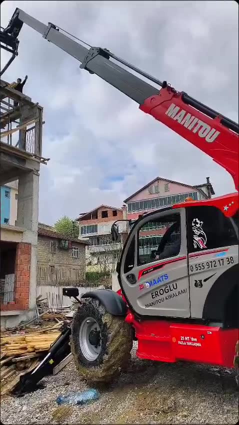Kırmızı Manitou teleskopik kolu yukarı uzanmış, kabinde Eroğlu Manitou Kiralama ve 0 555 972 17 38 yazısı